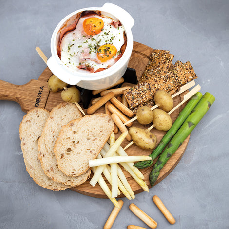 Camembert au four avec du jambon, des œufs et des légumes printaniers